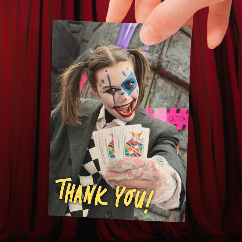 May include: A rectangular card featuring a person with clown makeup, pigtails, and a gray blazer over a black and white checkered shirt. The person holds playing cards with a jester illustration. The text THANK YOU is printed in yellow.