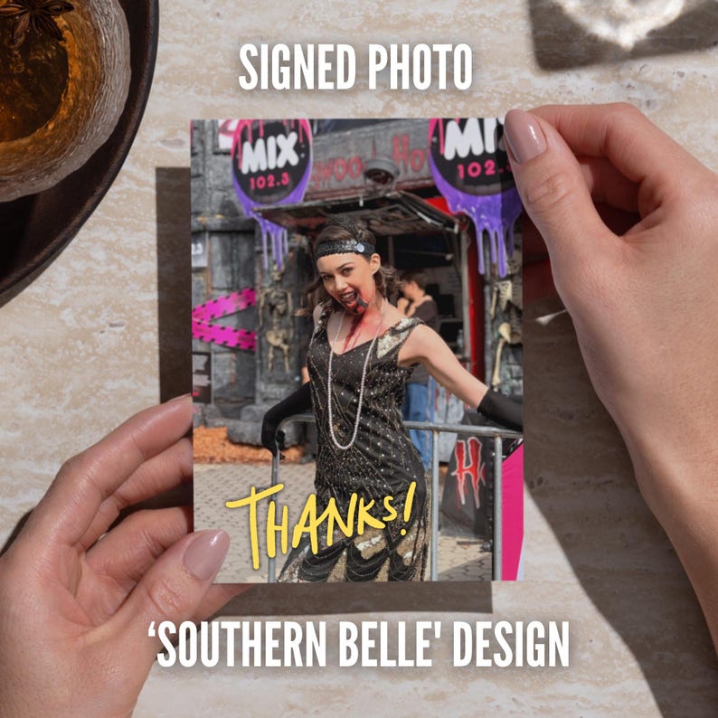 May include: A rectangular signed photo featuring a person in a black flapper-style dress with sequins, a headband, and black gloves, appearing as a zombie with blood effects. The photo includes the yellow text THANKS! printed at the bottom.