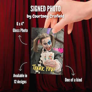 May include: A 6 x 4 inch gloss photo signed by Courtney Crisfield featuring a person in clown makeup with pigtails, wearing a dark blazer and a checkered shirt, holding playing cards with the yellow text THANK YOU! printed at the bottom.