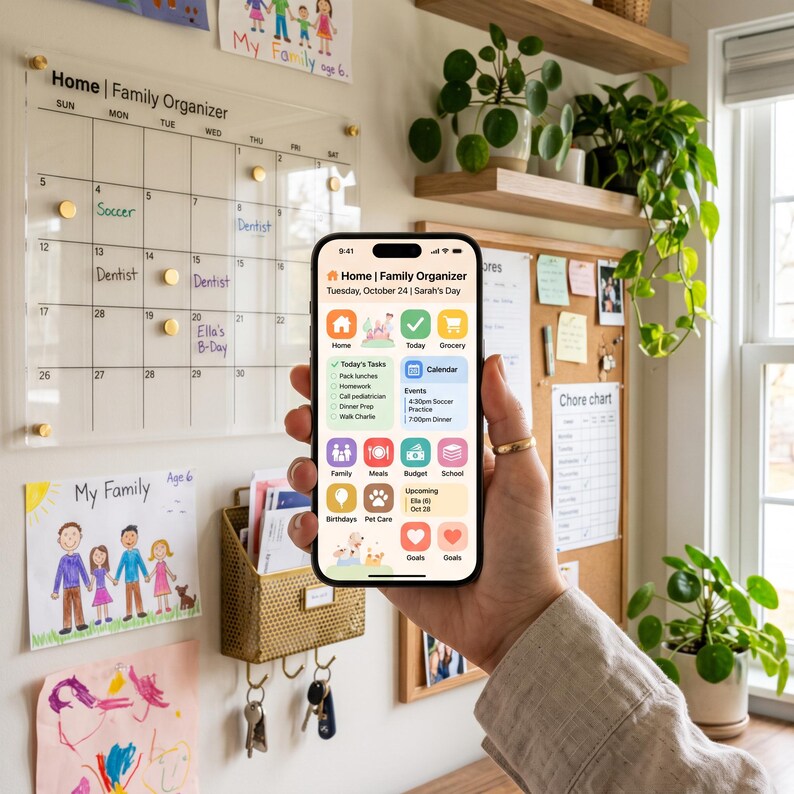 May include: A smartphone displaying a Home Family Organizer app interface with colorful icons for tasks, calendar, meals, budget, and school. The screen shows Tuesday, October 24, and Sarah's Day. The app features a light background with pastel-colored squares.