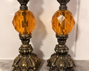 Par de castiçais vintage em acrílico âmbar e latão ornamentado, estilo Hollywood Regency.