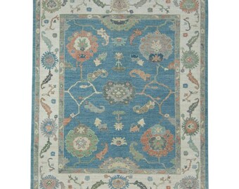 Tapete turco Oushak azul celeste, feito à mão em lã com borda floral marfim.