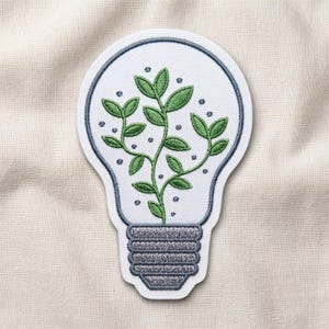 May include: An embroidered patch shaped like a light bulb with a white background and a dark gray border. Inside the bulb, a green plant with multiple leaves grows from the base, surrounded by small dark gray dots representing air bubbles.
