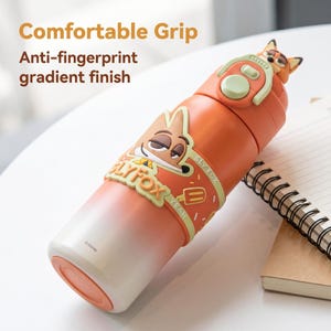 May include: Orange and white insulated water bottle with a cartoon fox design. The bottle features the text "Sly Fox" and "Yeah". The bottle has a comfortable grip and anti-fingerprint gradient finish. The top of the bottle has a fox head design.