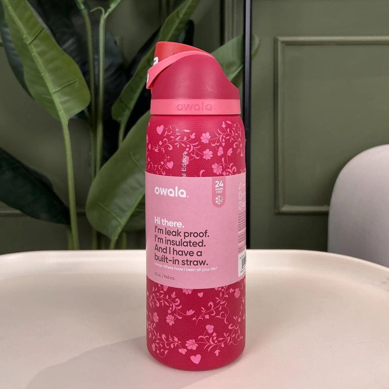 Puede incluir: Una botella de agua Owala roja con un dise&ntilde;o floral. La botella tiene una pajita incorporada y es a prueba de fugas y aislada. La tapa es rosa y tiene una capacidad de 946 ml.