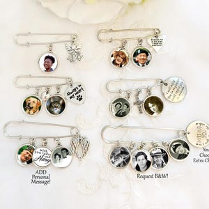 May include: Silver memorial pins with photo charms and decorative accents. Each pin features a safety pin base with multiple charms, including photo pendants, angel wings, and heart-shaped pendants. Some pins include text like "Always in my heart" and "Missing You".