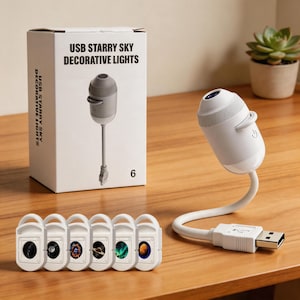 May include: A white USB starry sky decorative light with a flexible cable and a power button on the main unit. The set includes six small, square, white interchangeable lens caps featuring various space-themed graphics, packaged in a white box.