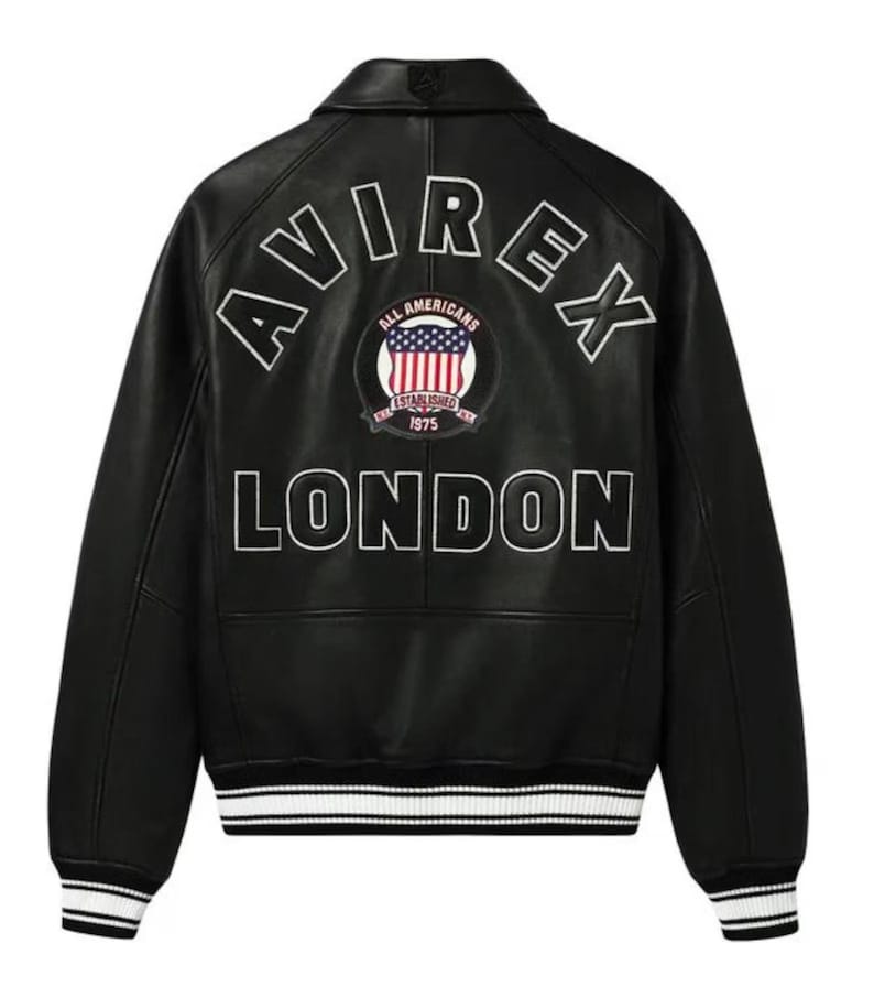 May include: Black leather jacket with white lettering that reads "AVIREX LONDON" on the back. The jacket has a patch with the American flag and the words "ALL AMERICANS ESTABLISHED 1975". The jacket has white and black striped cuffs.