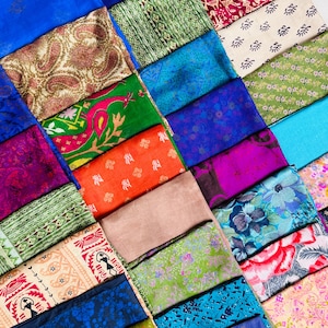 Könnte beinhalten: Eine Sammlung farbenfroher Seidenschals, die in einem Raster angeordnet sind. Die Schals zeigen eine Vielzahl von Mustern, darunter Paisley-, Blumen- und geometrische Designs. Die Farben reichen von tiefen Blau- und Lilatönen bis hin zu leuchtenden Grün-, Orange- und Rosatönen. Das Bild zeigt eine vielfältige Auswahl an Textildesigns.