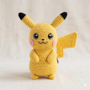 Könnte beinhalten: Handgemachte gelbe Pikachu-Häkelpuppe mit schwarzspitzigen Ohren, rosa Wangen und einem blitzförmigen Schwanz. Das Plüschtier hat große schwarze Augen und ein kleines Lächeln. Die Puppe ist etwa 15 cm groß.