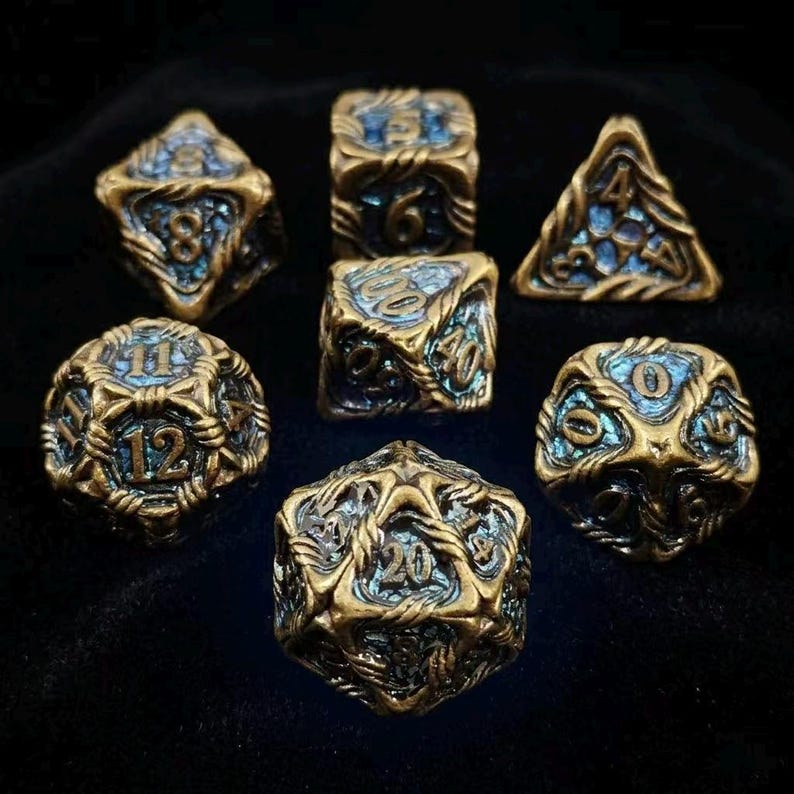 May include: Set of seven antique brass-colored polyhedral dice with blue accents. Each die features intricate designs and clearly visible numbers. Ideal for tabletop gaming, these dice are a unique addition to any collection.