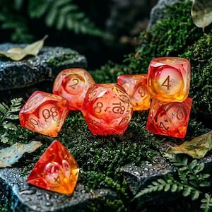 Puede incluir: Un conjunto de dados translúcidos de color naranja y amarillo con números dorados, colocados sobre un lecho de musgo verde. Los dados tienen varias formas, incluyendo una pirámide, un cubo y una esfera, y están diseñados para juegos de mesa.