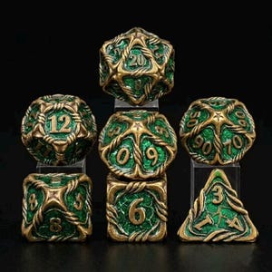 May include: Set of seven polyhedral dice in green and gold. The dice are designed with a detailed, interwoven pattern. The numbers are clearly visible in a contrasting color. Includes a D20, D12, D10, D8, D6, D4, and a D10 percentile die.