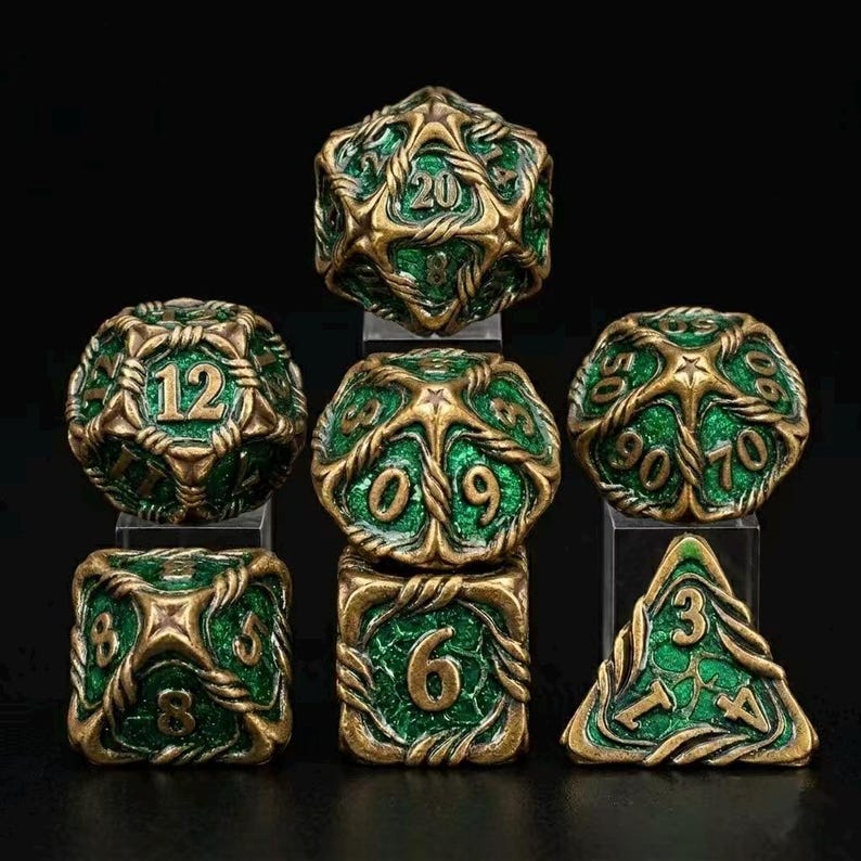 May include: Set of seven polyhedral dice in green and gold. The dice are designed with a detailed, interwoven pattern. The numbers are clearly visible in a contrasting color. Includes a D20, D12, D10, D8, D6, D4, and a D10 percentile die.