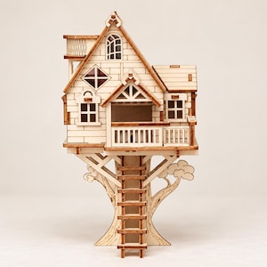 May include: A light-colored wooden treehouse model featuring a multi-level structure with a peaked roof, a balcony, multiple windows, and a central ladder leading up to the main platform. The design includes intricate laser-cut details and textures.