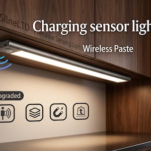 May include: A silver charging sensor light is mounted under a wooden cabinet. The light is rectangular and emits a bright glow. The text "Charging sensor light Wireless Paste" is visible. The image also shows icons for upgraded features.