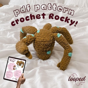 May include: A brown crocheted spider toy with turquoise accents, displayed on a white surface. The text "pdf pattern crochet Rocky!" is above the spider. A tablet shows a pattern for the toy. The Looped label logo is in the bottom right corner.