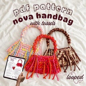 May include: Three crocheted handbags with braided handles and hanging tassels in pastel, bright pink and orange, and brown and cream colorways. A digital tablet displays a PDF pattern titled Nova handbag with tassels, featuring instructions.