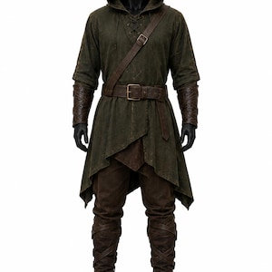 May include: A dark olive green hooded tunic with a lace-up neckline, worn with a brown leather belt and a matching diagonal shoulder strap. The outfit includes dark brown arm bracers and tall, lace-up brown boots over dark brown trousers.