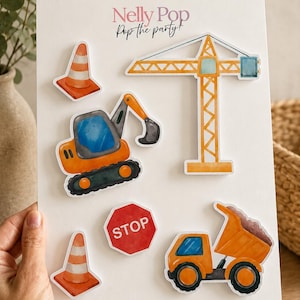 May include: A collection of construction-themed stickers on a white background. The stickers include an orange crane, a dump truck, an excavator, traffic cones, and a stop sign. The text "Nelly Pop Pop the party!" is at the top.