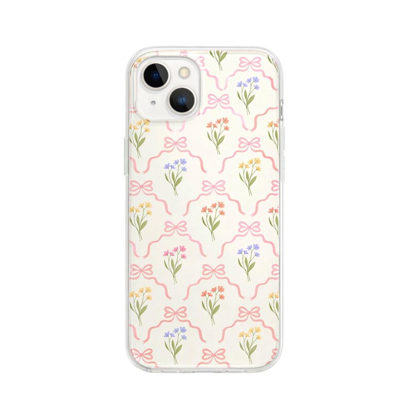 May include: Clear phone case with a repeating pattern of pink bows and colorful floral bouquets. The flowers are yellow, orange, and blue. The case has a clear border and a camera cutout.