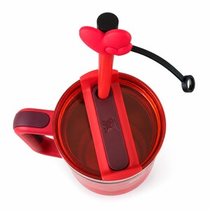 May include: A red insulated tumbler with a clear lid, a dark red handle, and a red straw topped with a red heart-shaped accessory. The lid features a dark red sliding closure mechanism with a small embossed logo of a bird with wings spread.