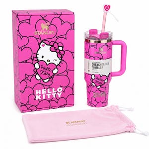 May include: A bright pink Stanley Quencher H2.0 tumbler featuring a Hello Kitty heart pattern, a matching pink box with Hello Kitty graphics, and a light pink drawstring pouch. The tumbler includes a clear straw with a heart-shaped topper.