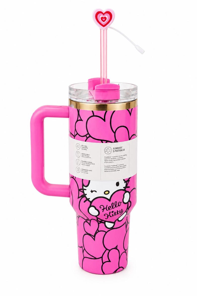 May include: A bright pink insulated tumbler featuring a repeating heart pattern and a Hello Kitty graphic. The cup includes a pink handle, a clear lid with a 3-position FlowState mechanism, and a pink straw topped with a heart-shaped charm.
