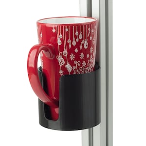 May include: A red ceramic mug with a white holiday-themed pattern of ornaments, snowflakes, and gift boxes, held securely within a black cylindrical cup holder attached to a vertical silver aluminium extrusion profile rail.