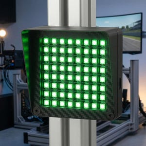 May include: A square LED flag display featuring a grid of sixty-four bright green lights arranged in an eight-by-eight pattern. The device is encased in a black housing with a carbon fibre texture and is mounted onto a vertical aluminium profile.