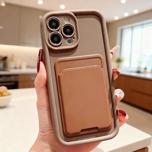May include: A brown and tan phone case with a built-in cardholder. The case has a rectangular design with rounded corners and a raised camera module. The cardholder is a lighter shade of brown and is rectangular with a curved top.