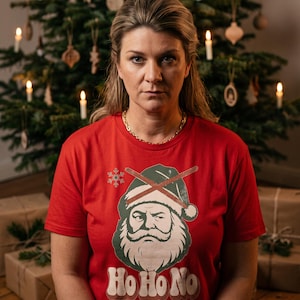 Peut inclure: Un t-shirt rouge à manches courtes avec une illustration d'un Père Noël barbu portant un bonnet barré d'une croix, accompagné du texte Ho Ho No en lettres blanches et d'un petit flocon de neige au-dessus du bonnet.
