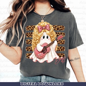May include: A charcoal gray t-shirt featuring a graphic of a white ghost with blonde curly hair, a pink bow, and a pink acoustic guitar. The ghost is positioned over four horizontal leopard print stripes. The word Dolly is written in pink script.