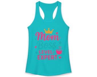 May include: A turquoise racerback tank top with the words "Mom Boss LEVEL: EXPERT" in pink and a gold crown graphic. The design includes stars, hearts, and a coffee cup graphic.