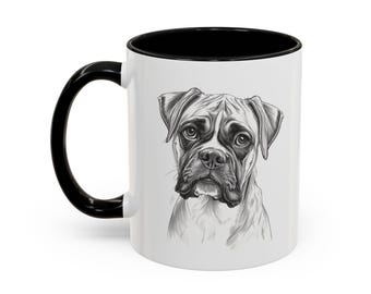 May include: White ceramic mug with a black handle and interior. The mug features a detailed black and white illustration of a Boxer dog's face. The dog's expression is focused, with detailed fur and facial features.