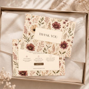 Puede incluir: Dos tarjetas de agradecimiento florales con fondo beige y flores burdeos y beige. Las tarjetas están dentro de una caja de cartón. El texto "THANK YOU" está impreso en una etiqueta rectangular. El texto adicional incluye "LET'S CONNECT" y "LOVE YOUR ORDER".
