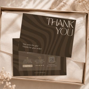 Puede incluir: Dos tarjetas de agradecimiento marrones con un patrón ondulado y las palabras "THANK YOU" en una fuente serif. Una tarjeta dice "This one's for you! Thanks for your order!" e incluye un código QR y un código de descuento.