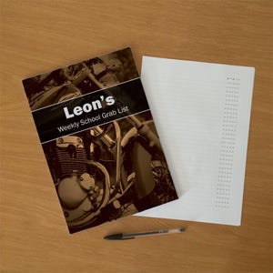 May include: A notepad with a cover featuring a sepia-toned motorcycle engine and the text Leon's Weekly School Grab List. The interior page is white with horizontal lines and a vertical column of checkboxes labelled with M T W T F headers.