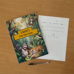 Könnte beinhalten: Ein täglicher Schlaf-Tracker mit einem Dschungel-Motiv auf dem Einband, das einen Gorilla, Tiger, Affen, Papagei, Tukan und eine Eidechse zeigt. Der Text lautet Lizzie's Daily Sleep Tracker. Ein weißes Blatt und ein schwarzer Stift liegen daneben.