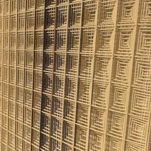 Puede incluir: Un tapiz de pared con un patr&oacute;n de cuadr&iacute;cula geom&eacute;trica compuesto por cuerdas de fibra en capas con forma cuadrada. El dise&ntilde;o muestra un degradado de tonos neutros, desde beige claro y tostado hasta marr&oacute;n oscuro, creando un motivo texturizado.