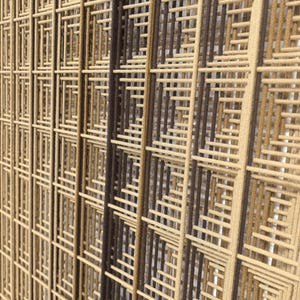 Puede incluir: Una pieza de arte mural que presenta una serie de paneles verticales compuestos por hilos estrechamente tejidos en tonos beige, bronceado y marr&oacute;n oscuro. Los hilos est&aacute;n dispuestos en un patr&oacute;n de rejilla geom&eacute;trica repetitivo.