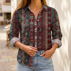 Op de afbeelding: Een overhemd met lange mouwen en knoopsluiting, voorzien van een verticaal gestreept patroon met gedetailleerde paisley-motieven en bloemendesigns in tinten donkerrood, blauwgroen en donkerblauw. Het overhemd heeft een klassieke kraag en lichte knopen.