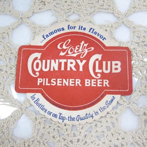 May include: Vintage Goetz Country Club Pilsener Beer label. The red label features white text and a circular design. The text includes "famous for its flavor" and "In Bottles or on Tap - the Quality is the Same."