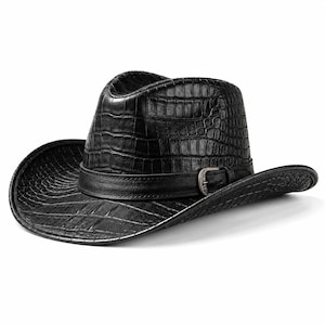 Op de afbeelding: Een zwarte cowboyhoed met een gestructureerd krokodillenleerpatroon over de kroon en de rand. De hoed is voorzien van een gladde zwarte leren band rond de basis, afgewerkt met een metalen gespdetail aan de zijkant van de hoed.