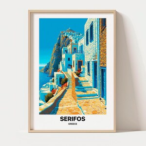 Op de afbeelding: Een ingelijste kunstdruk met een levendige illustratie van Serifos, Griekenland. De afbeelding toont witte gebouwen met blauwe deuren en ramen langs een stenen pad, tegen een rotsachtige klif en een helderblauwe zee. De tekst luidt SERIFOS GREECE.