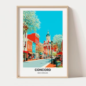 May include: A framed art print depicting a street scene in Concord, North Carolina. The illustration features colourful brick buildings, a central domed courthouse, black street lamps, and blooming trees under a bright blue sky. Text reads CONCORD NEW CAROLINA.