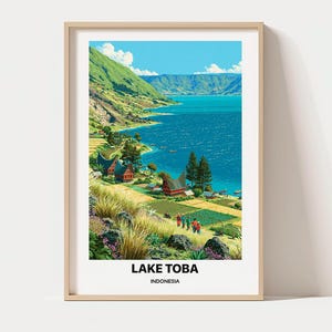 May include: A framed vertical art print depicting a landscape of Lake Toba in Indonesia. The scene features a bright blue lake, green mountains, traditional houses with curved roofs, terraced fields, and people walking. The text reads LAKE TOBA INDONESIA.