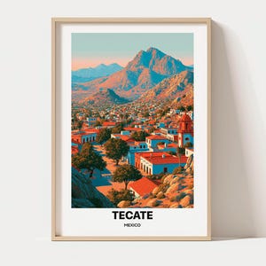 May include: A framed vertical art print featuring a landscape of Tecate, Mexico. The scene depicts a town with white buildings and red roofs nestled at the base of large, rocky mountains under a soft sky. The text TECATE MEXICO is printed below.