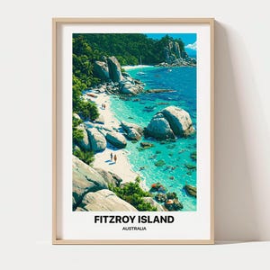 May include: A framed travel poster featuring a vibrant coastal scene of Fitzroy Island, Australia. The artwork displays turquoise waters, large granite boulders, lush green tropical vegetation, a white sandy beach, and the text Fitzroy Island Australia.