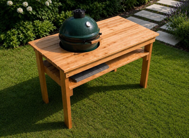 May include: A rectangular light brown wooden table with a slatted surface and a lower shelf. A dark green, dome-shaped ceramic grill with a silver temperature gauge and a black handle is set into a circular cutout on the top of the wooden table.
